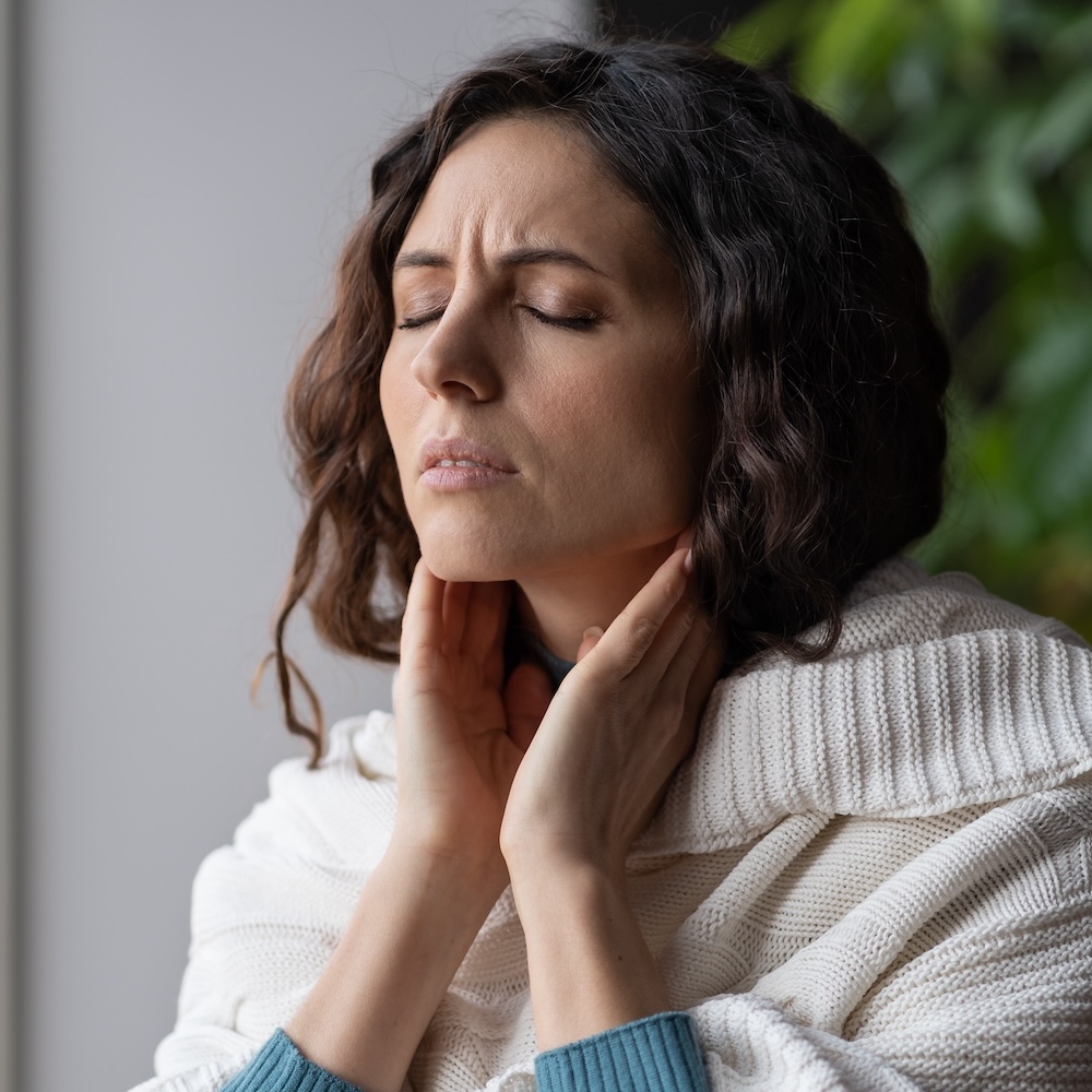 Sick woman suffer from sore throat touch enlarged lymph nodes staying home on sick leave. Unhappy young female with coronavirus disease, angina or pharyngitis illness symptoms. Girl feeling discomfort